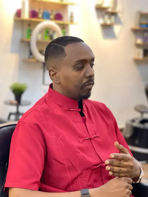 Sharp line-up with a razor side part on a short waves cut and shaped goatee, finished at Barberhood, JVC Dubai