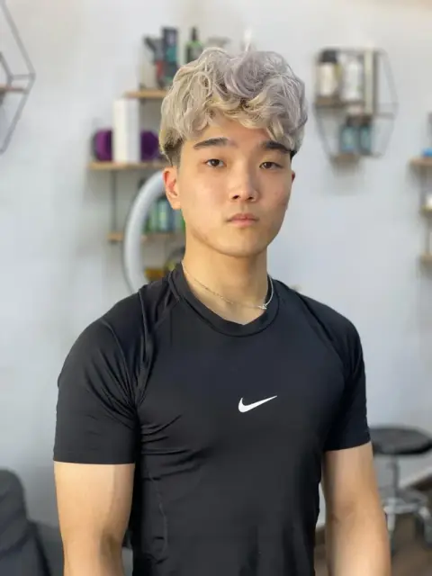 Ash-blond textured curls with tapered sides, coloured and cut at Barberhood men’s salon in JVC, Dubai
