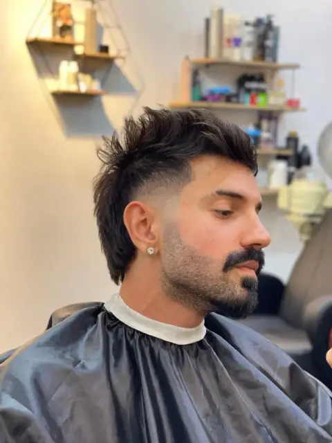 Modern mullet with a spiky textured top, faded sides and a shaped beard, styled at Barberhood in JVC, Dubai