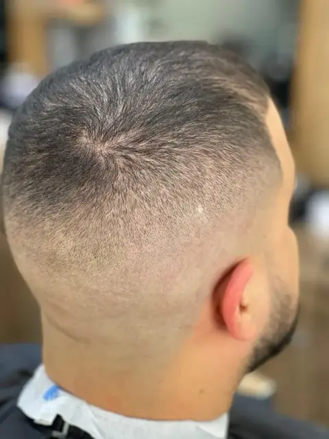 Crown view of a seamless high bald fade blended into a short crop at Barberhood barbershop, JVC Dubai