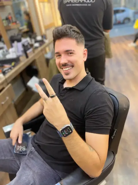 Smiling client in the chair after a short textured crop and moustache trim at Barberhood, JVC Dubai